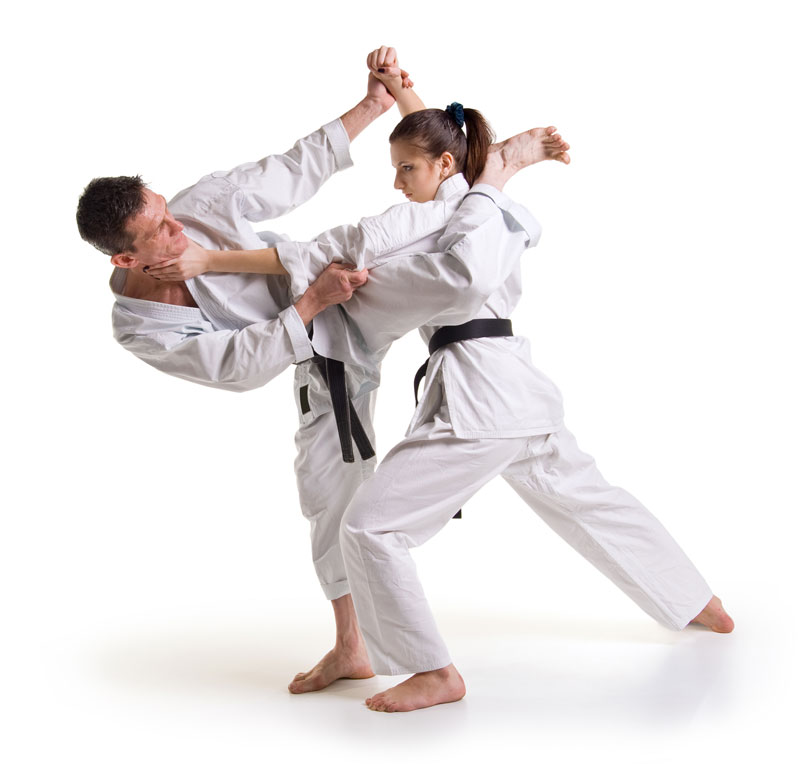 A man and woman, both adults, practicing martial arts techniques together